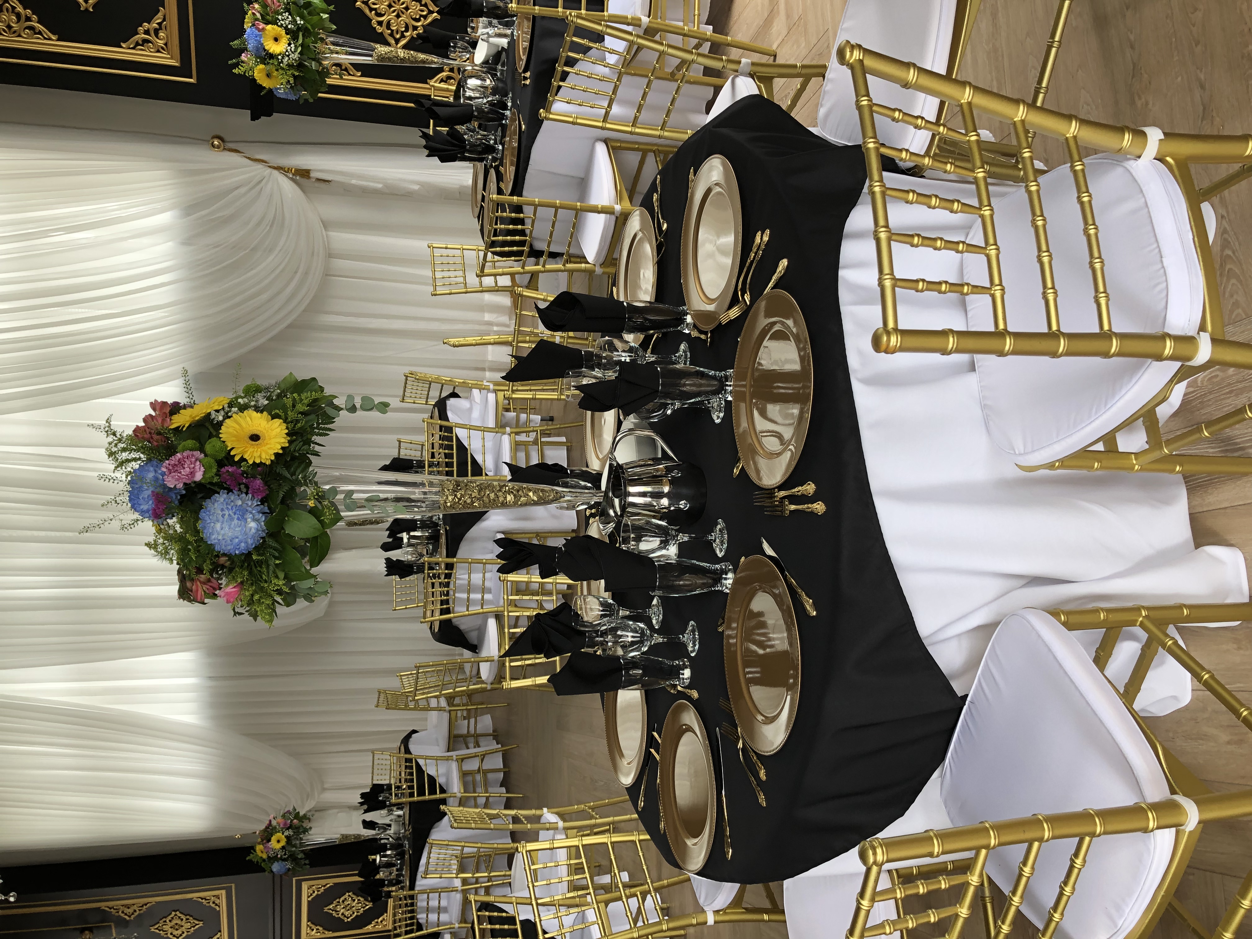 This image depicts chairs, linens, dishware and vases provided by All Celebrations.